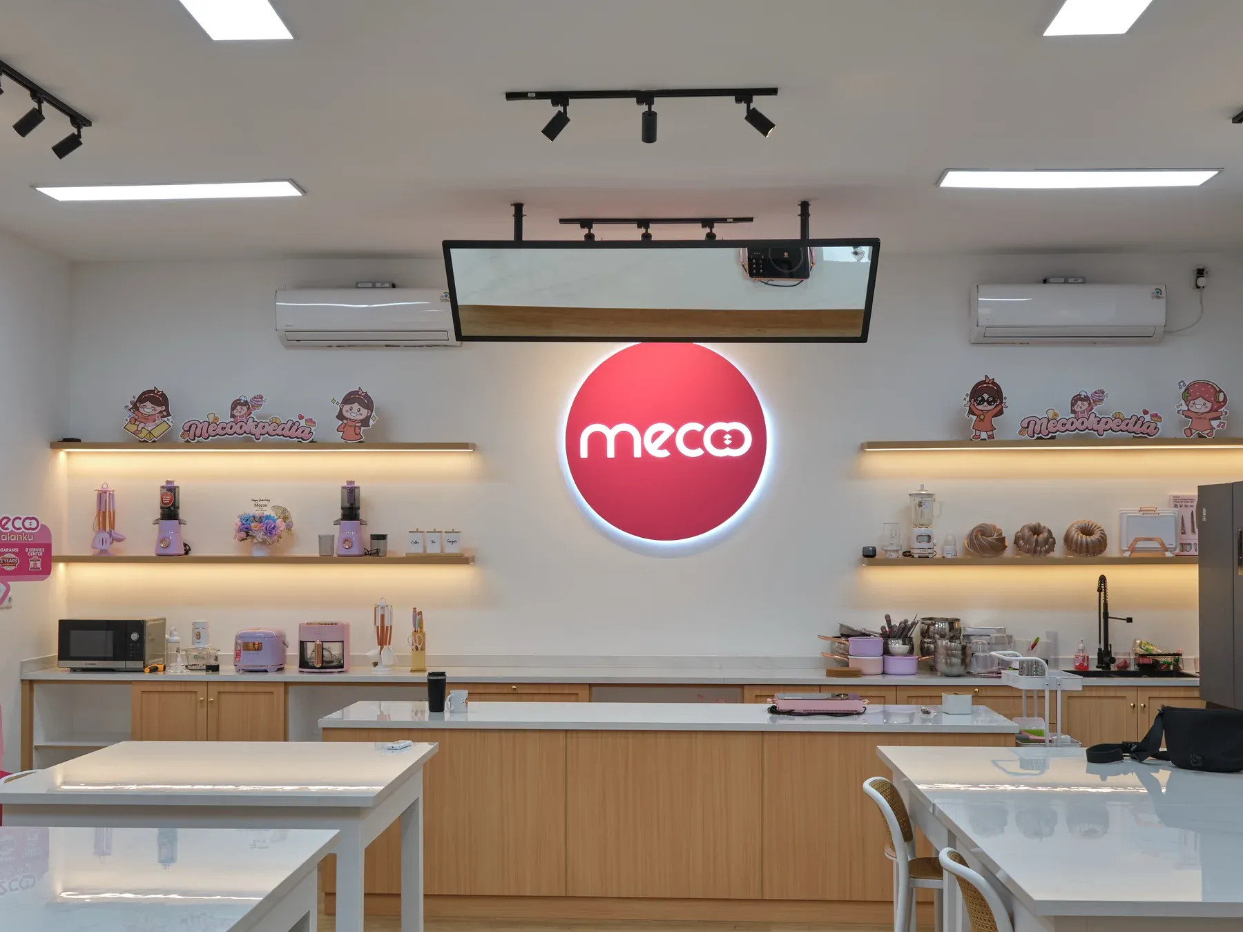 Ruang Mecoo Baking Center dengan rak produk dan meja kelas memasak